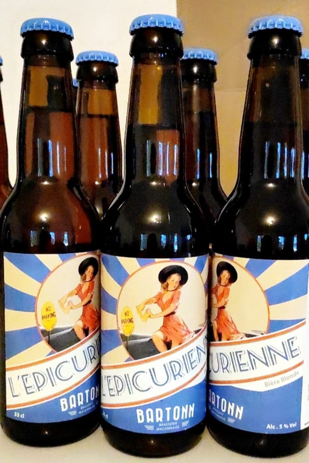 Bouteilles de bière blonde à l'étiquette L'Épicurienne, illustrée d'une pin-up rétro