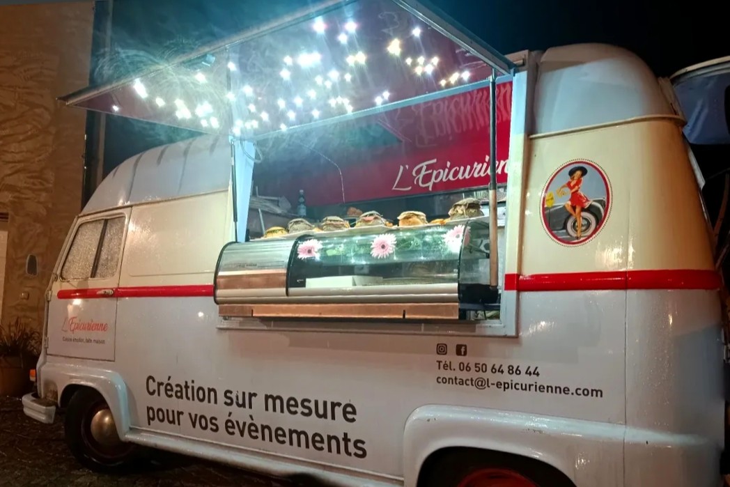 L'Estafette de L'Épicurienne de nuit, comptoir ouvert éclairé de guirlandes lumineuses, vitrine réfrigérée garnie de burgers